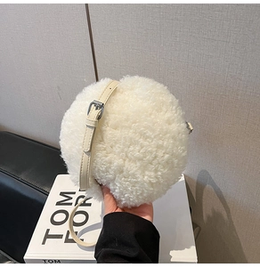 Detailed close-up of white fluffy lamb wool round crossbody bag with adjustable strap
