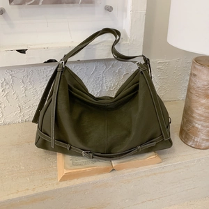 Detail of olive green leather tote bag featuring contrast stitching and adjustable straps