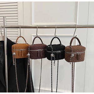 Detail of four quilted chain bags in mustard, coffee, black, and brown hanging on a rack