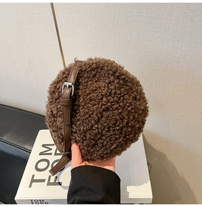 Detailed view of dark brown teddy plush round bag with adjustable leather strap