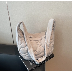 Gros plan détaillé du sac hobo matelassé gris clair avec texture en nylon rembourrée