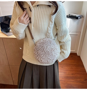 Detail of round shearling crossbody bag with leather strap and silver metal hardware