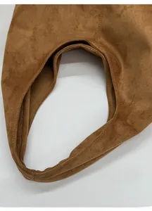 Détail de la large bandoulière confortable sur un cabas en daim marron aux coutures nettes