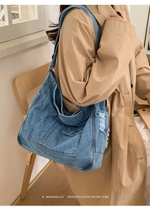 Detail of vintage blue denim tote bag with distressed fringes and pocket decorations
