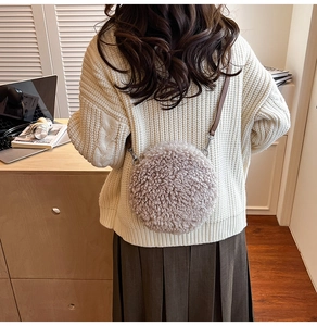 Detail of light coffee lamb wool round crossbody bag with brown leather shoulder strap