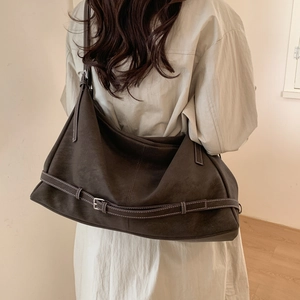 Detail view of deep brown tote bag with contrast stitching and metal buckle strap details
