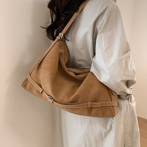 Detail view of large camel suede tote bag showing soft silhouette and strap adjustment