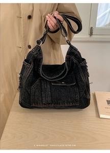 Detail of washed black denim tote bag featuring functional pockets and vintage frayed edges