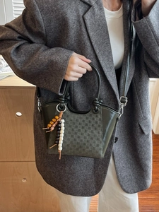 Sac seau vert foncé à motif damier avec pompon en perles et bandoulière réglable