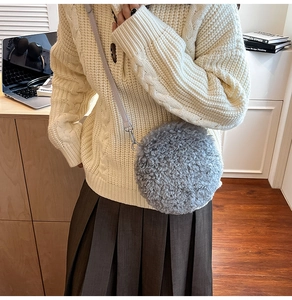 Detail of grey sherpa fleece round crossbody bag with leather strap on a model