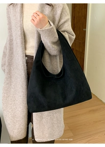 Détail d'un sac hobo minimaliste en daim noir avec un design rétro en demi-lune