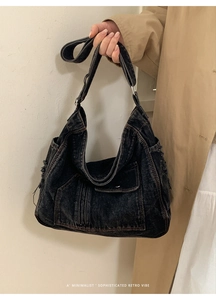 Detailed close-up of retro washed denim shoulder bag with brown contrast stitching