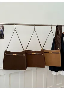 Gros plan de sacs cabas en daim mat avec boucles CD en diverses teintes de brun