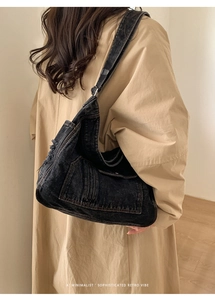 Close-up of vintage washed denim tote bag with visible stitching and retro fringe details