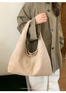 Gros plan sur le fourre-tout en daim beige montrant sa grande capacité et son style rétro