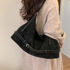 Detail of black tote bag with white contrast stitching and adjustable buckle straps