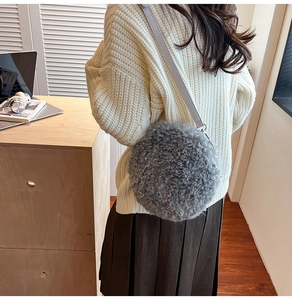 Detail of grey sherpa round crossbody bag showing soft texture and silver strap buckle