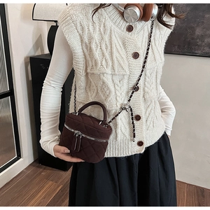 Quilted burgundy mini bucket bag with silver chain strap worn by a female model