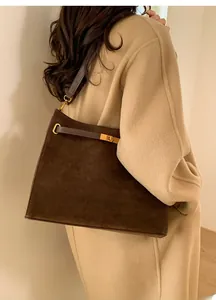 Détail du sac cabas en daim marron foncé avec fermoir doré et bandoulière en cuir gris