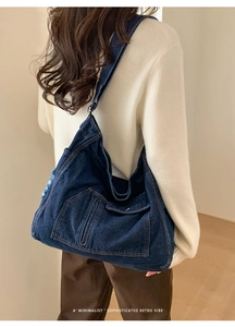 Detail of dark blue washed denim tote bag with functional pockets and a retro vibe