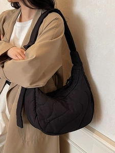 Sac à bandoulière demi-lune matelassé noir avec rembourrage doux porté par mannequin