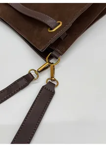 Gros plan de la boucle métallique et du daim sur un grand sac cabas élégant