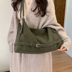 Detail of olive green leather tote bag featuring contrast white stitching and silver buckles