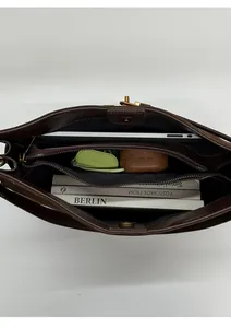 Vue de dessus montrant l'intérieur spacieux du cabas en daim marron avec des objets