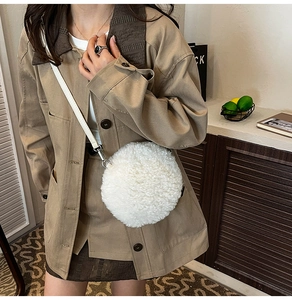 Close-up of white plush crossbody bag with soft faux fur texture and slim leather strap