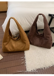 Vue macro de deux grands sacs hobo en daim en couleurs caramel et marron foncé