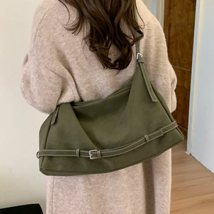 Detail of army green hobo tote bag featuring visible white stitching and buckle accents