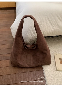 Détail de la texture en daim marron doux et de la large bandoulière d'un grand sac cabas