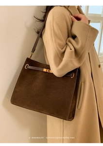 Détail du sac cabas en daim marron foncé avec boucle dorée et design rétro élégant