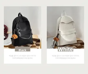 Detail of minimalist leather backpacks in black and white with cute puppy pendants