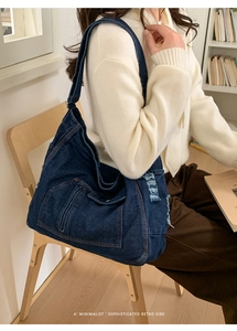 Detail of frayed edge denim tote bag with side pocket in a minimalist retro vibe style