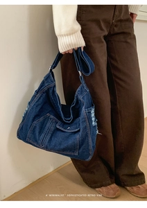 Close-up of retro denim bag showing frayed edges and textured vintage blue fabric