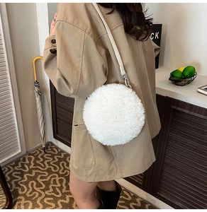 Detail of white plush round shoulder bag with silver hardware and leather strap
