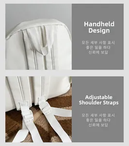 Detail view of reinforced top handle and adjustable shoulder straps on white backpack