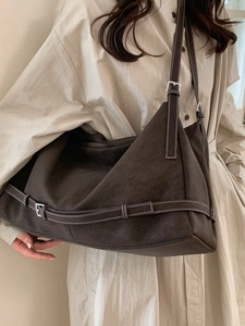 Deep brown minimalist suede tote bag with white contrast stitching and adjustable straps
