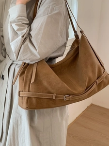 Minimalist brown suede tote bag for women shown with grey coat in a stylish indoor setting