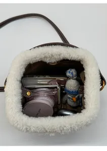 Vue de dessus du sac seau en peluche montrant l'intérieur spacieux et la fermeture magnétique
