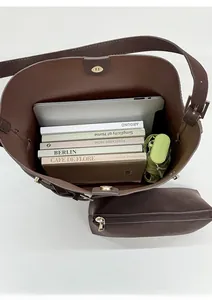 Top view of spacious brown leather bucket bag showing interior storage with laptop and books