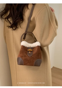 Détail d'un sac seau rétro en daim marron avec bordure en fourrure blanche et fermoir doré
