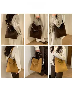Detail shot of large bucket bags in coffee and yellow with decorative scarves on handles