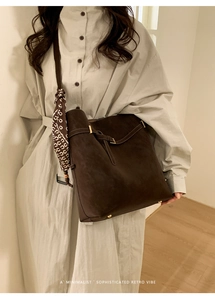 Detail of retro dark brown suede tote bag with decorative silk scarf and metal studs