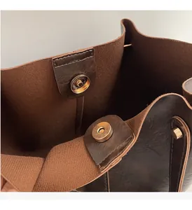 Détail d'un sac cabas marron foncé montrant le fermoir magnétique doré et la doublure