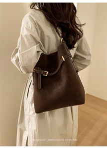 Deep brown retro bucket bag shown on shoulder, highlighting minimalist style and large size