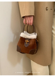 Détail du sac seau rétro en daim avec bordure en fausse fourrure et fermoir doré