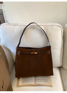 Détail du cabas mat marron foncé avec boucle dorée et texture en daim rétro