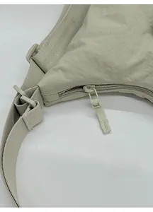 Detail of the smooth zipper with pull cord and ripstop nylon fabric on the beige tote bag